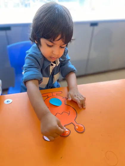 Another angle showing the careful placement of googly eyes on a craft. These details matter to the children and we celebrate their precision.