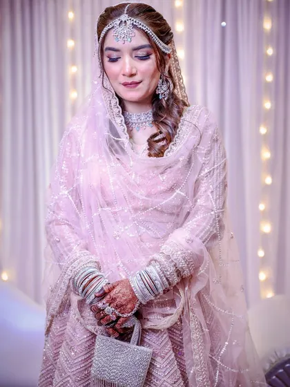 A full-length shot of this bride in her shimmering pink lehenga. She looks like a princess.