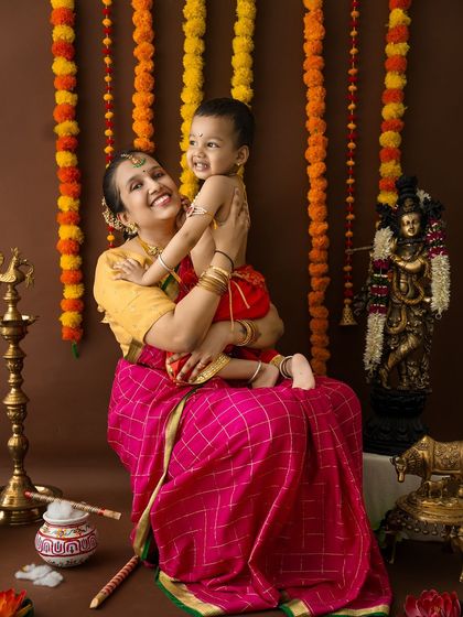 A playful lift captures the pure happiness of this mother and her little Krishna during their festive photoshoot.