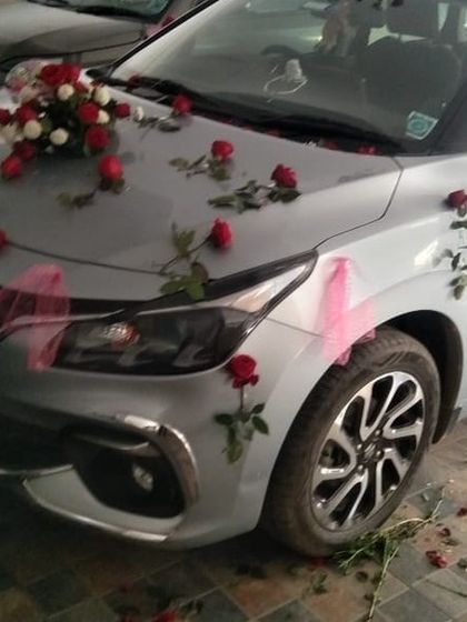 A simple decoration on a silver Baleno, using a small bouquet and scattered red roses for a subtle and classy look.