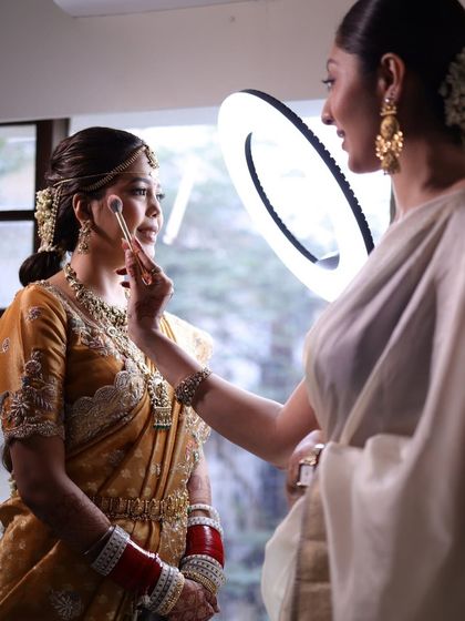 A behind the scenes shot of the makeup artist giving final touches, with my hairstyle providing the perfect canvas.