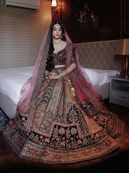 Crafting timeless elegance in a rich velvet lehenga. This full-length shot shows how the makeup and open hairstyle create a modern yet traditional bridal look.