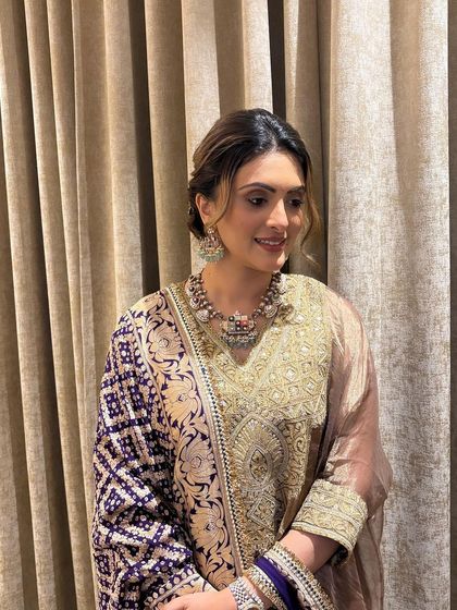 The client looks radiant with her soft, textured updo. The loose tendrils frame her face beautifully, giving her a gentle and romantic look.