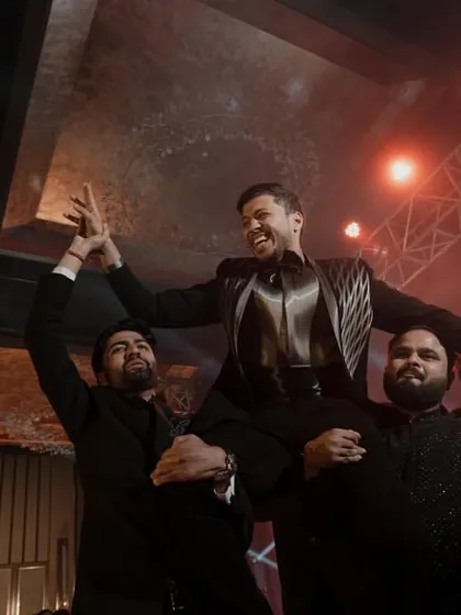 The groom being lifted by his friends in celebration. Pure joy and brotherhood.