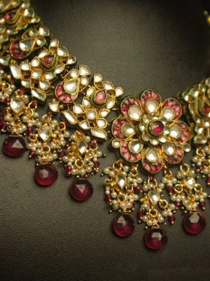 A close-up of our elegant white and red Kundan set. The floral motif and ruby-red drops create a stunning contrast, making it a perfect choice for a bridal look.