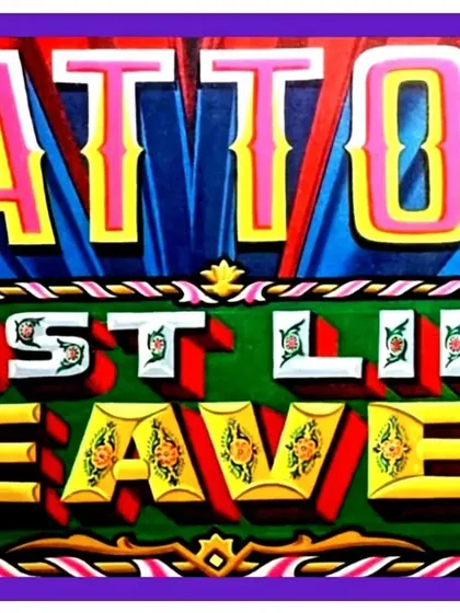 A close-up of the "Tattoo Just Like Heaven" portion of the Neon Moon sign, showing the detailed, decorated lettering.
