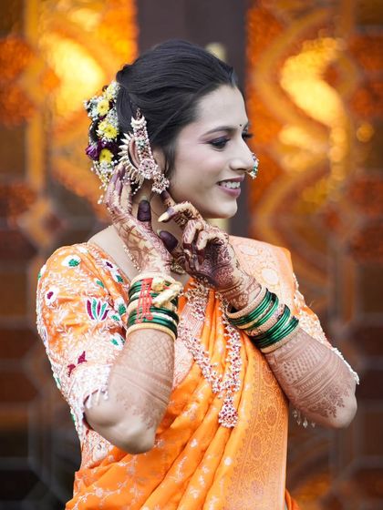 A beautiful portrait of the bride adjusting her traditional ear cuff, a moment of grace and elegance.