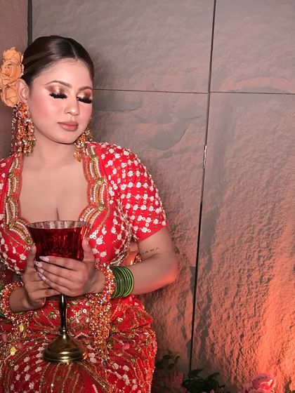 A serene and elegant pose, with eyes closed to highlight the beautiful eyeshadow work and the delicate floral hairpiece.