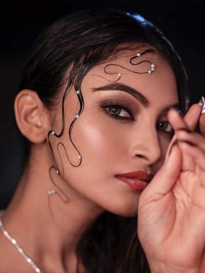 This is a fine art beauty portrait where every detail matters. The carefully styled wet hair with pearls, the smoky eye makeup, and the subtle lighting combine to create a truly artistic image.