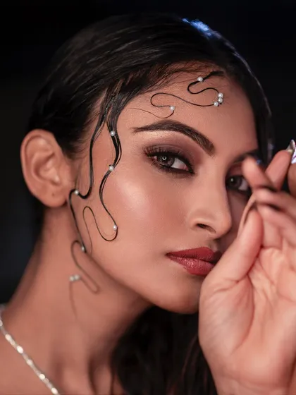 This is a fine art beauty portrait where every detail matters. The carefully styled wet hair with pearls, the smoky eye makeup, and the subtle lighting combine to create a truly artistic image.