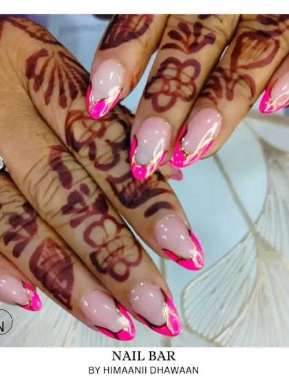 A vibrant and festive look. These nails feature a bright pink design with gold accents, perfectly matching the intricate mehendi for a celebratory feel.