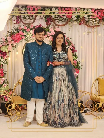 A full view of this stunning couple. The groom's teal sherwani adds a pop of color, making them stand out at their event.