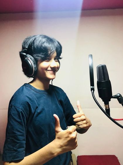 Thumbs up from the vocal booth. This student is all smiles during her recording session, feeling like a true professional.