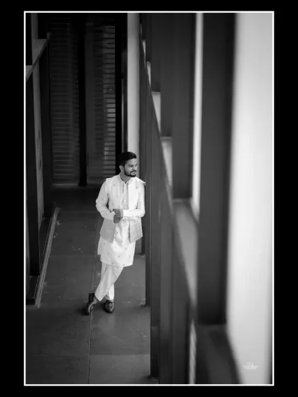 A timeless black and white portrait of the groom. The use of architectural lines and natural light creates a pensive and stylish shot.