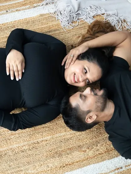 A relaxed, top-down view of you two connecting. Lying on a rustic jute mat, this pose feels natural and intimate, perfect for a casual yet beautiful maternity couple photo.