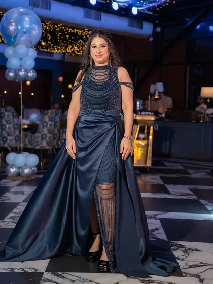 Another stunning gown from our collection, this one in a deep navy blue with a satin trail and beaded bodice. It’s the epitome of cocktail glamour.