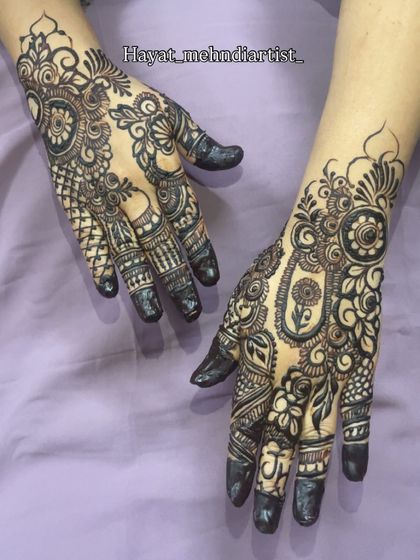A classic Pakistani henna design, known for its very fine, intricate lines and dense patterns. The black henna makes the details pop.