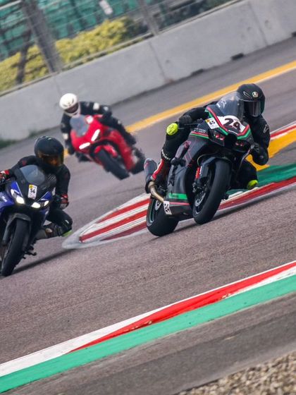 A trio of racers, each on a different line, attack a corner. This shot highlights the different techniques and strategies employed by riders during a race.