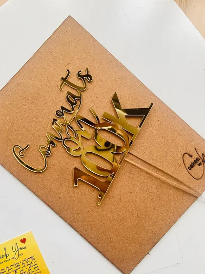 Celebrate your social media milestones! This "Congrats on 100K" topper is perfect for influencers, brands, or anyone celebrating a big achievement.