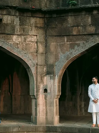 Using the symmetry of the twin arches, this shot creates a powerful visual story of two individuals connected yet distinct, set against a backdrop of ancient stone.