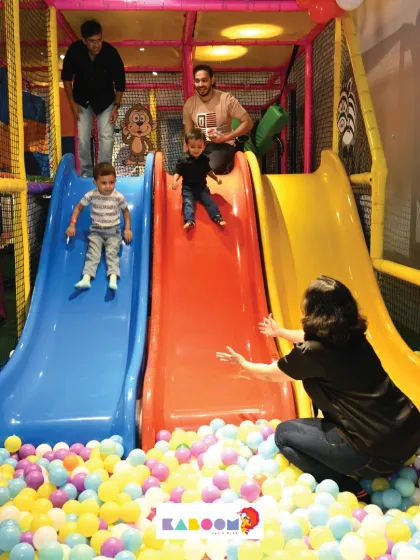 Family fun time! Parents can join in on the fun too, helping their little ones slide into the ball pit safely.