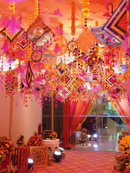 The ceiling of this Mehendi hall was a canopy of color. I used traditional Rajasthani hangings, kites, and tassels to create a vibrant and festive atmosphere that filled the entire space.