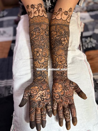 A classic full bridal mehendi with intricate details covering every part of the hands and arms, perfect for the traditional bride.