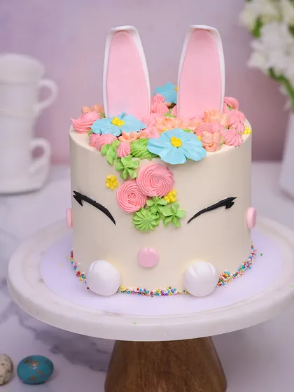 Our Easter Bunny Cake is a springtime delight, with sleepy eyes, colorful sprinkles, and a crown of buttercream flowers.