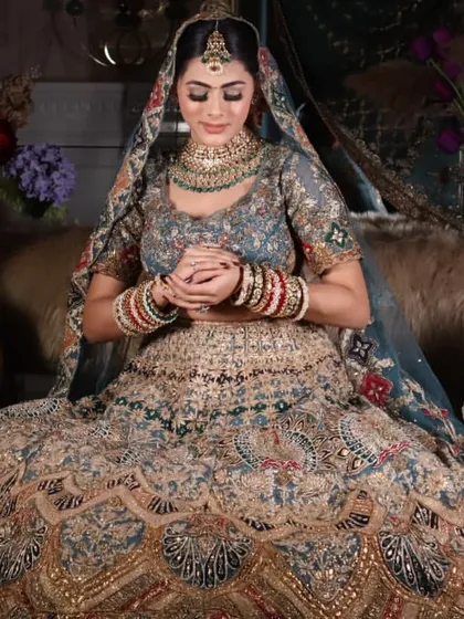 A serene bridal pose, showcasing the full glory of the lehenga and the soft, complementary makeup.
