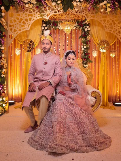 The royal couple seated on their wedding stage. The bride's intricate lehenga and diamond jewellery set make her look like a modern-day princess.