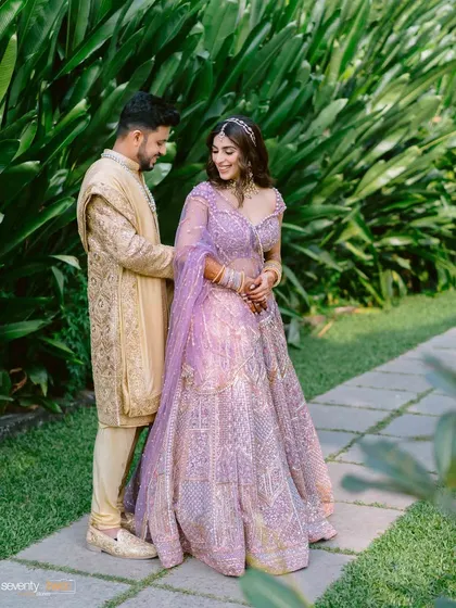 A classic couple portrait in a garden pathway in Goa, the lush greenery providing a perfect, natural frame for their love.