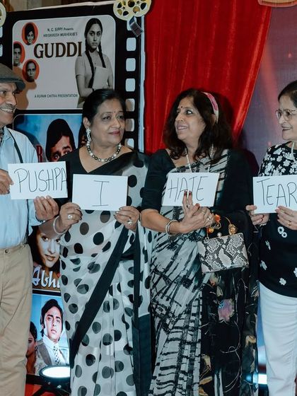 Interactive games are a great way to bring a theme to life. Here, guests are having fun recreating a famous Bollywood dialogue, "Pushpa I hate tears." This kind of playful activity is perfect for breaking the ice at company parties.