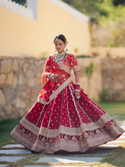 The bride showing off the beautiful flare of her red wedding lehenga. A perfect shot to capture the grandeur of the outfit.