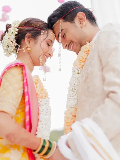 An intimate moment during a Marathi wedding ritual where the couple touches foreheads. Their gentle smiles and close embrace convey a deep sense of connection and happiness.