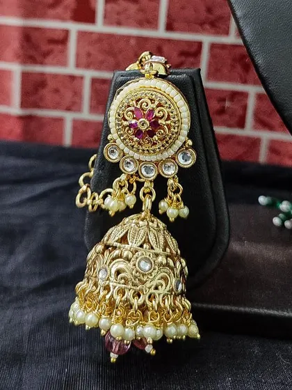 The matching jhumka earring, featuring a detailed floral top.