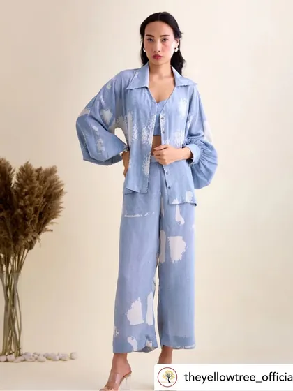 This beautiful three-piece set in a powder blue abstract print is from our showcase at The Yellow Tree. The oversized shirt, crop top, and wide-leg pants create a relaxed yet chic look, perfect for daily wear.