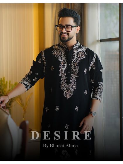 Elegance is an attitude. This classic black kurta is transformed by intricate silver and gold embroidery around the collar and down the placket. It is a versatile piece of luxury menswear, designed for moments that matter.