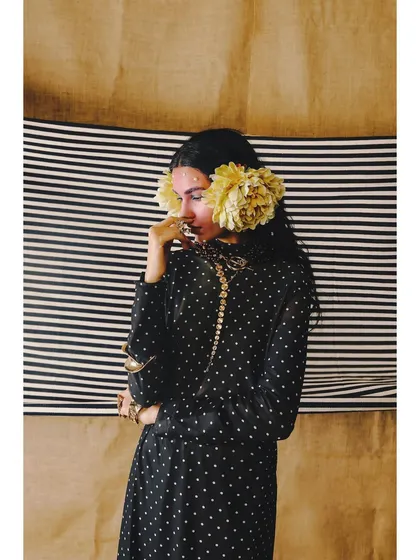 A portrait from 'Neo-Boheme', focusing on the unconventional styling of using large flowers as ear accessories. This showcases a creative and artistic approach to fashion.