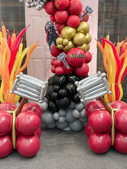 This arrangement features Thor's mighty hammer, Mjolnir, sculpted from balloons. These powerful-looking props were part of a larger installation, adding to the immersive superhero experience.