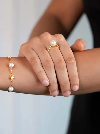 Golden elegance, pearl perfection. This image captures the timeless bond between two people, reflected in the classic beauty of a pearl bracelet and ring set. A perfect gift to show your love.