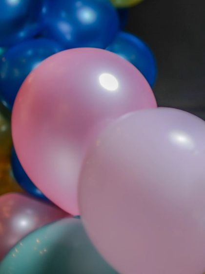 A close-up of pink and blue balloons, showing the soft, pearly finish that adds to the party's aesthetic.
