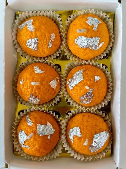 A top-down view of my box of six laddoo candles. Each one is handcrafted from 100% soy wax and finished with edible silver vark for an authentic look.