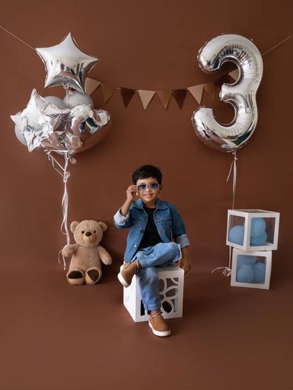 Adjusting his shades, this little guy is the definition of cool during his third birthday photoshoot.