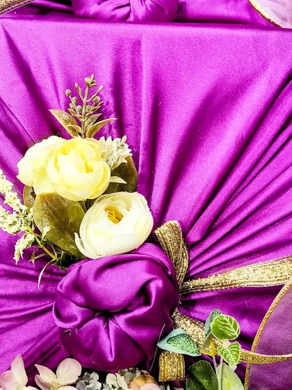 This is an example of Furoshiki, a traditional Japanese fabric wrapping technique I use for a unique and sustainable touch. For this engagement ceremony, I wrapped sweets and nuts in this beautiful purple fabric, finished with delicate floral accents.
