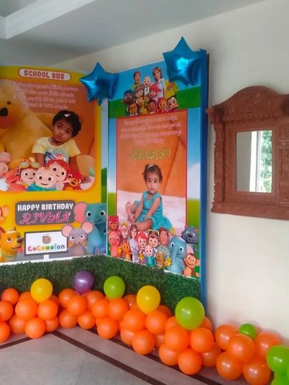 We can create personalized backdrops for your child's birthday, like this Cocomelon-themed one. It features custom-printed posters with the child's photos, surrounded by character cutouts and a vibrant orange and green balloon arrangement.