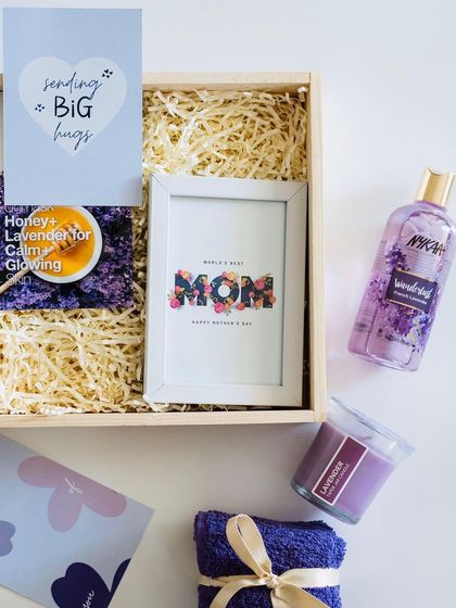A lavender-themed Mother's Day hamper, designed for relaxation. It includes a 'Best Mom' frame, lavender-scented candle and shower gel, and a soft towel.