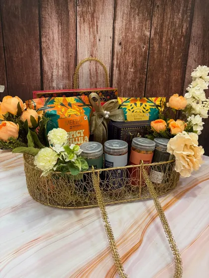 A larger version of our desi snack hamper, this boat-shaped basket is overflowing with savory farsaan, sweet mithai, and beautiful floral decorations.
