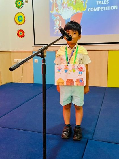A young storyteller uses a character board to illustrate his tale of 'The Three Little Pigs' during an in-school competition.