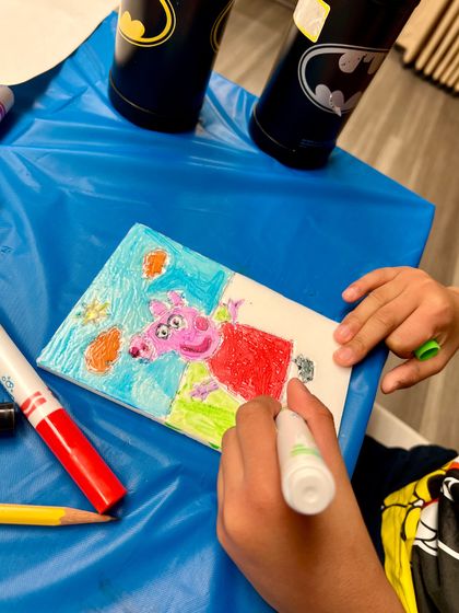 A young artist coloring a Peppa Pig design for their print. Our workshops are all about making art that is personal and fun.