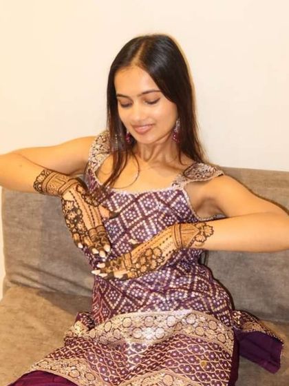 The groom's sister looking absolutely radiant while showing off her beautiful henna design.